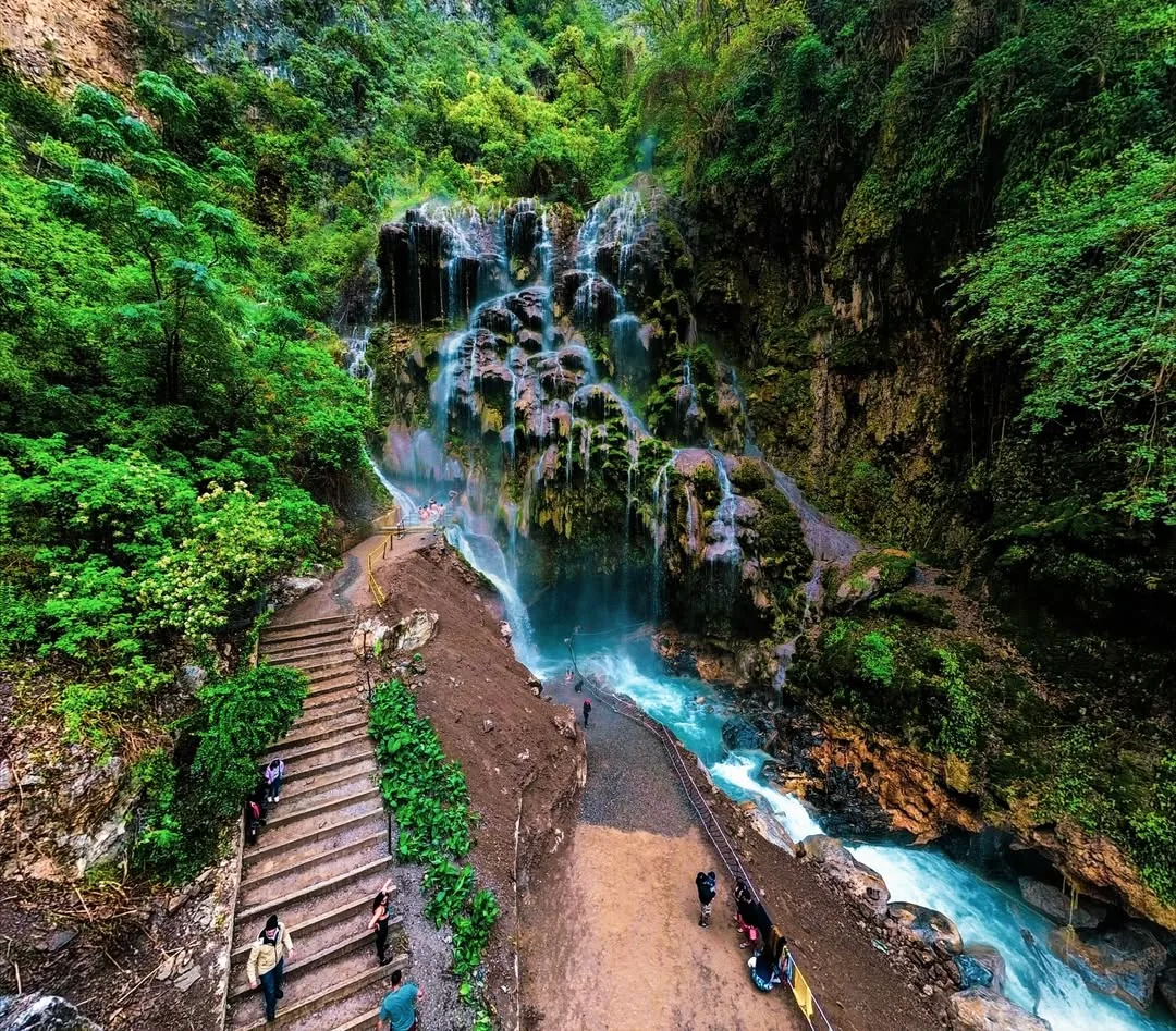 Natural stone trail through canyon vegetation at Tolantongo with a river view