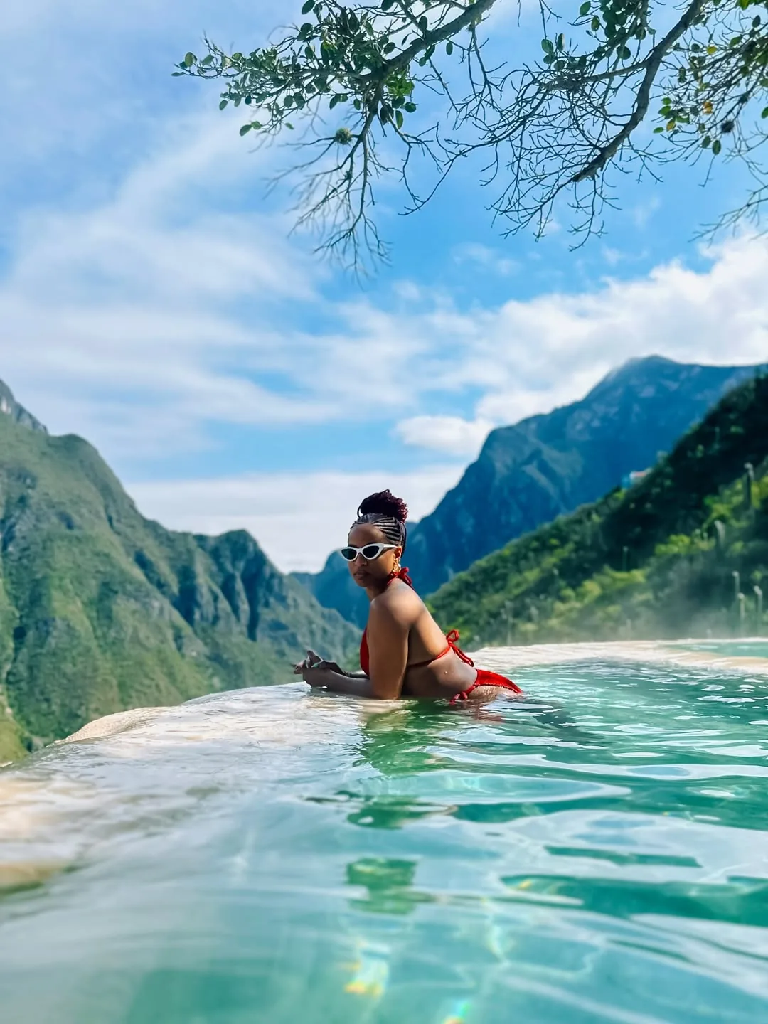 Woman with sunglasses enjoying the warm infinity pool