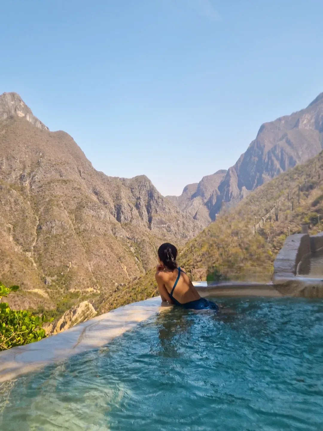 Woman enjoying the infinity pool with canyon landscape