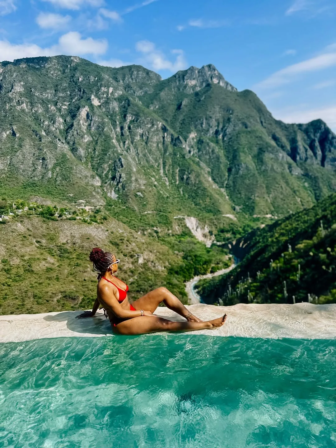 Woman in red swimsuit at the infinity pool with panoramic canyon views