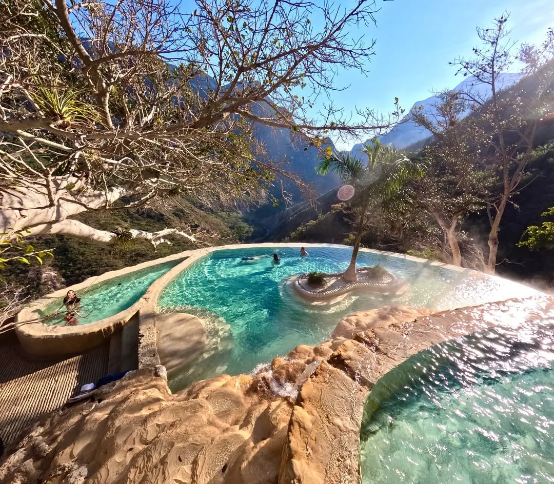 Round natural thermal pool carved in limestone rock