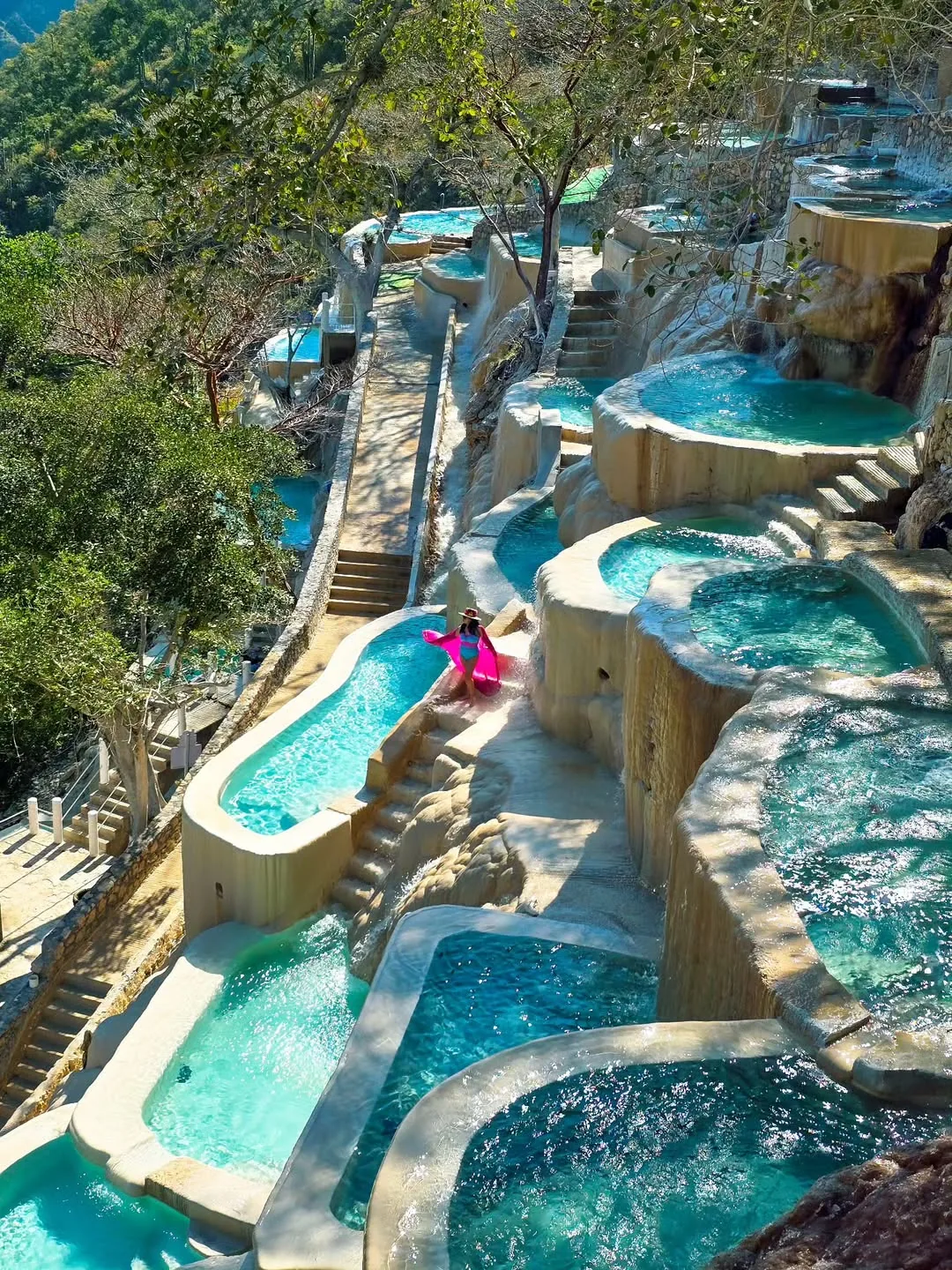 Woman with pink sarong at the edge of a thermal pool